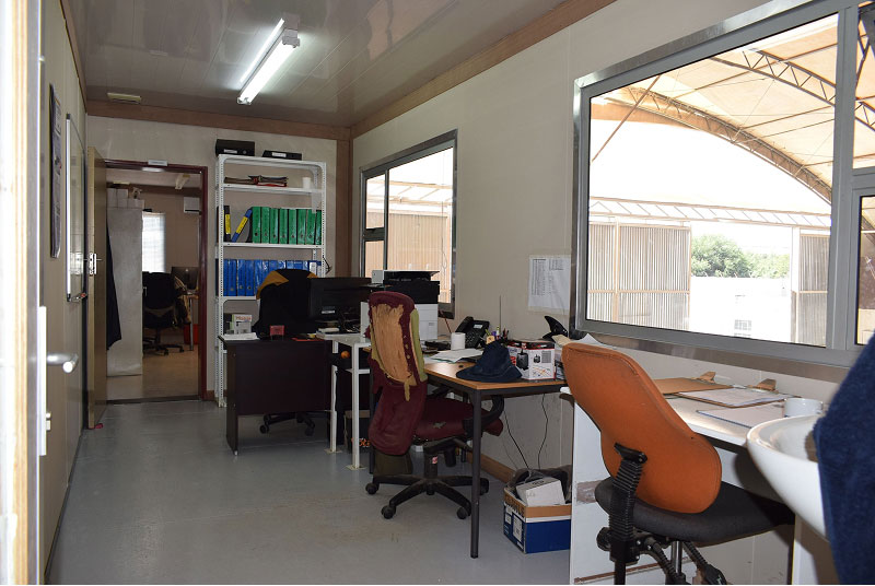 inside of office container with desks and chairs